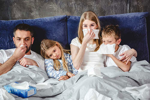 خانواده مریض و سرما خورده روی تخت