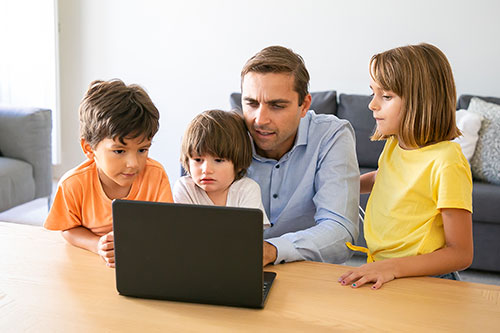 عکسی از یک پدر و 3 فرزندش که دارن به صفحه لپ تاپ نگاه میکنن