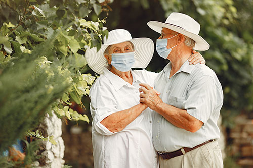 تصویری از یک پیرمرد و پیرزن که ماسک دارند و عاشقانه در حال رقصیدن هستند