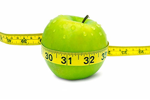 عکسی از یک سیب که دور آن را با متر اندازه گیری کردند