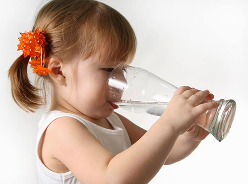 تصویری از یک کودک که دارد با یک لیوان بزرگ آب میخورد
