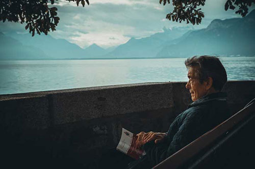 پیرمردی که روی صندلی نشسته و به دریا نگاه میکند