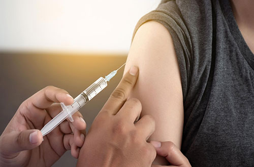 تصویری از بازو یک مرد مریض که دارد واکسن میزند