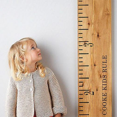 تصویری از یک کودک که میخواهد قد خود را اندازه بگیرد